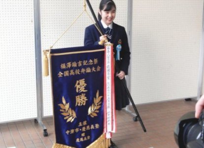 優勝旗を手に記念撮影に応じる井本さん